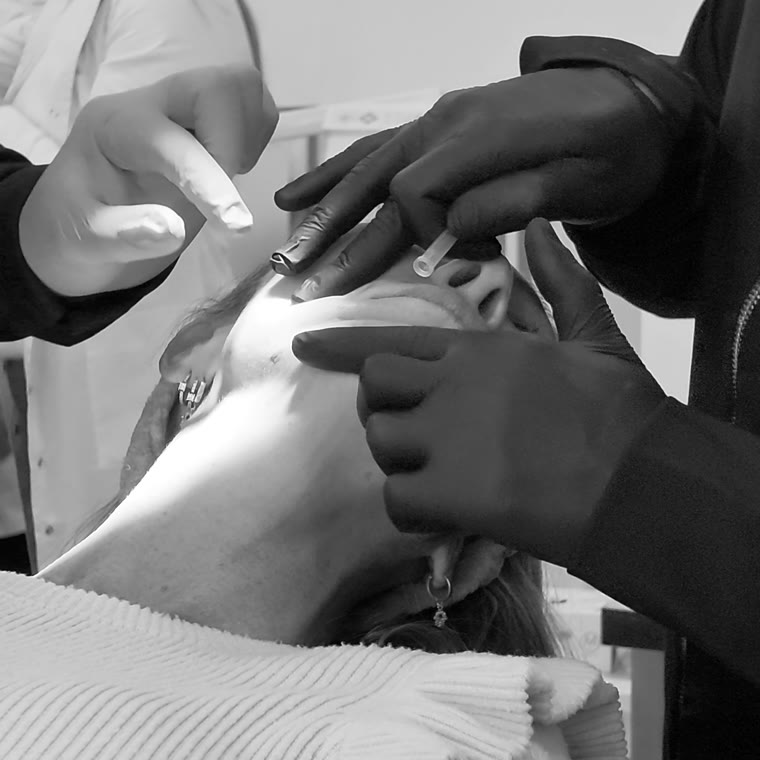 Un médico inyectando con la mano del Dr. Kallas guiando